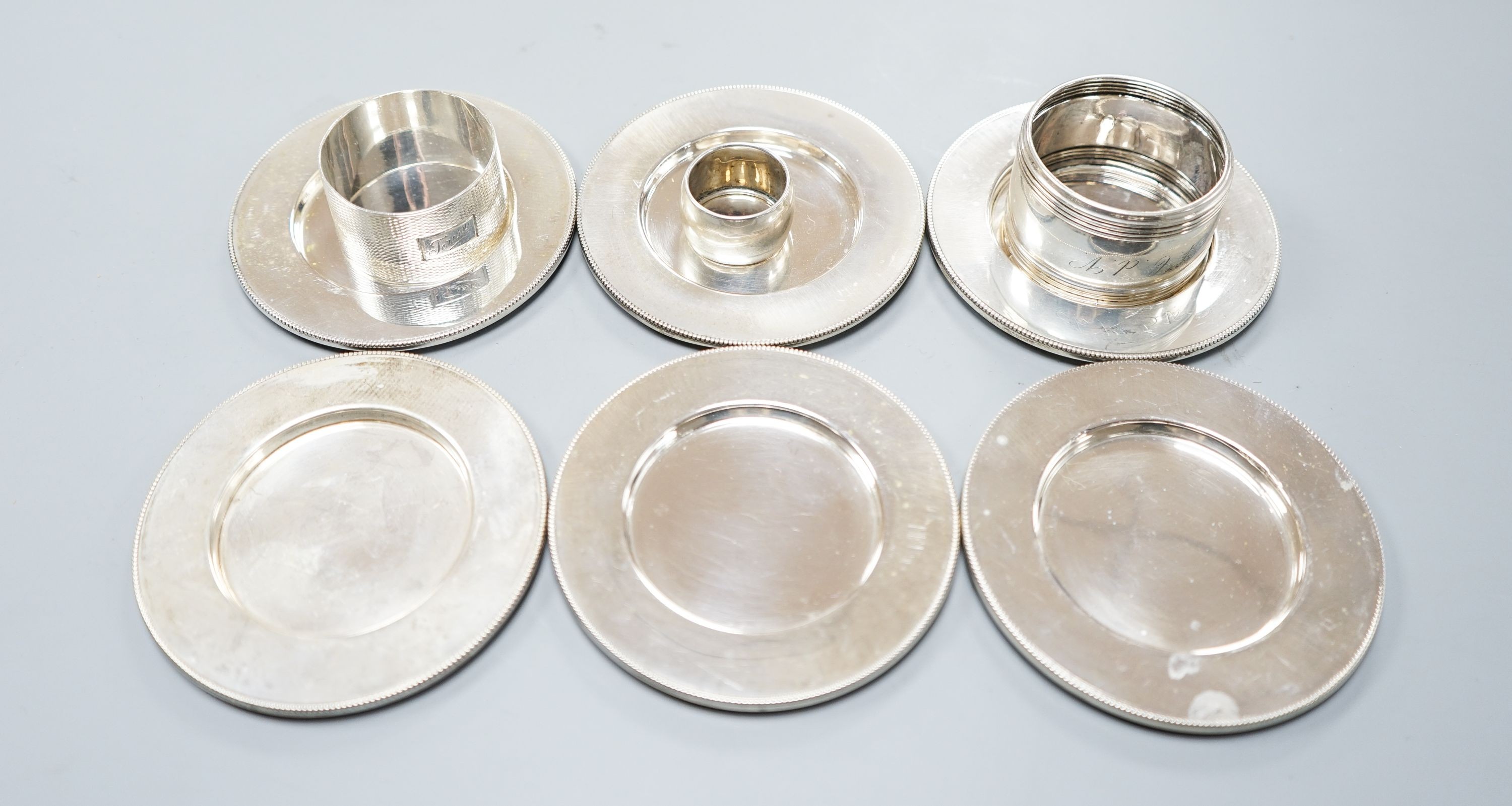 Six 830 standard white metal coasters and three napkin rings